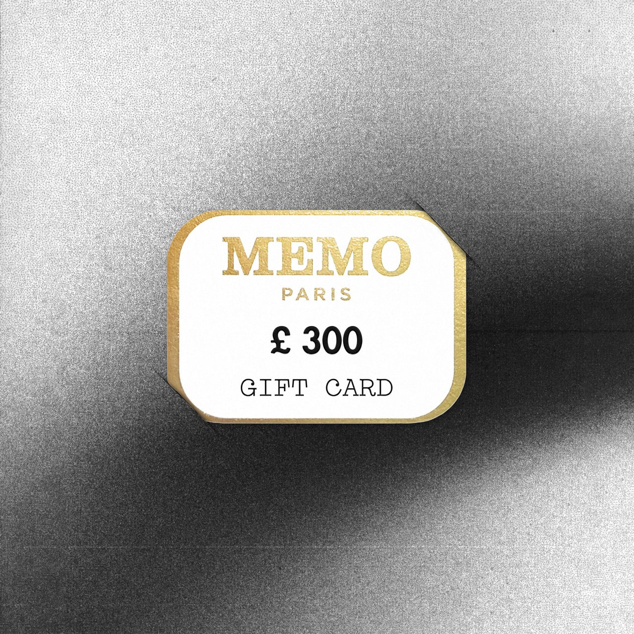 Carte cadeau Memo Paris blanche et or à la typographie élégante, d'une valeur de 300 livres, célébrant des destinations de rêve