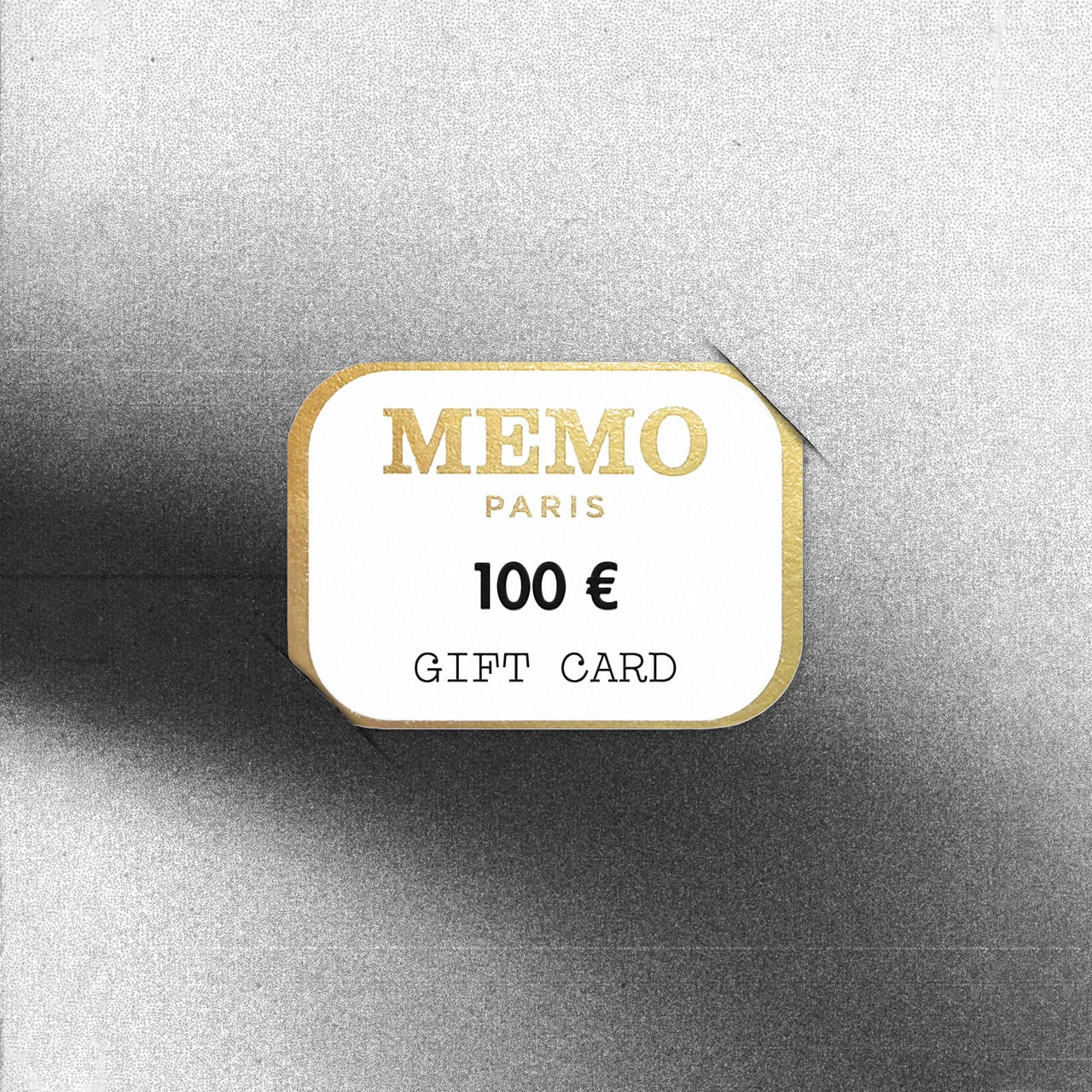 A white and gold memo paris gift card with elegant embossed lettering and 100 euro value celebrating dream destinations
