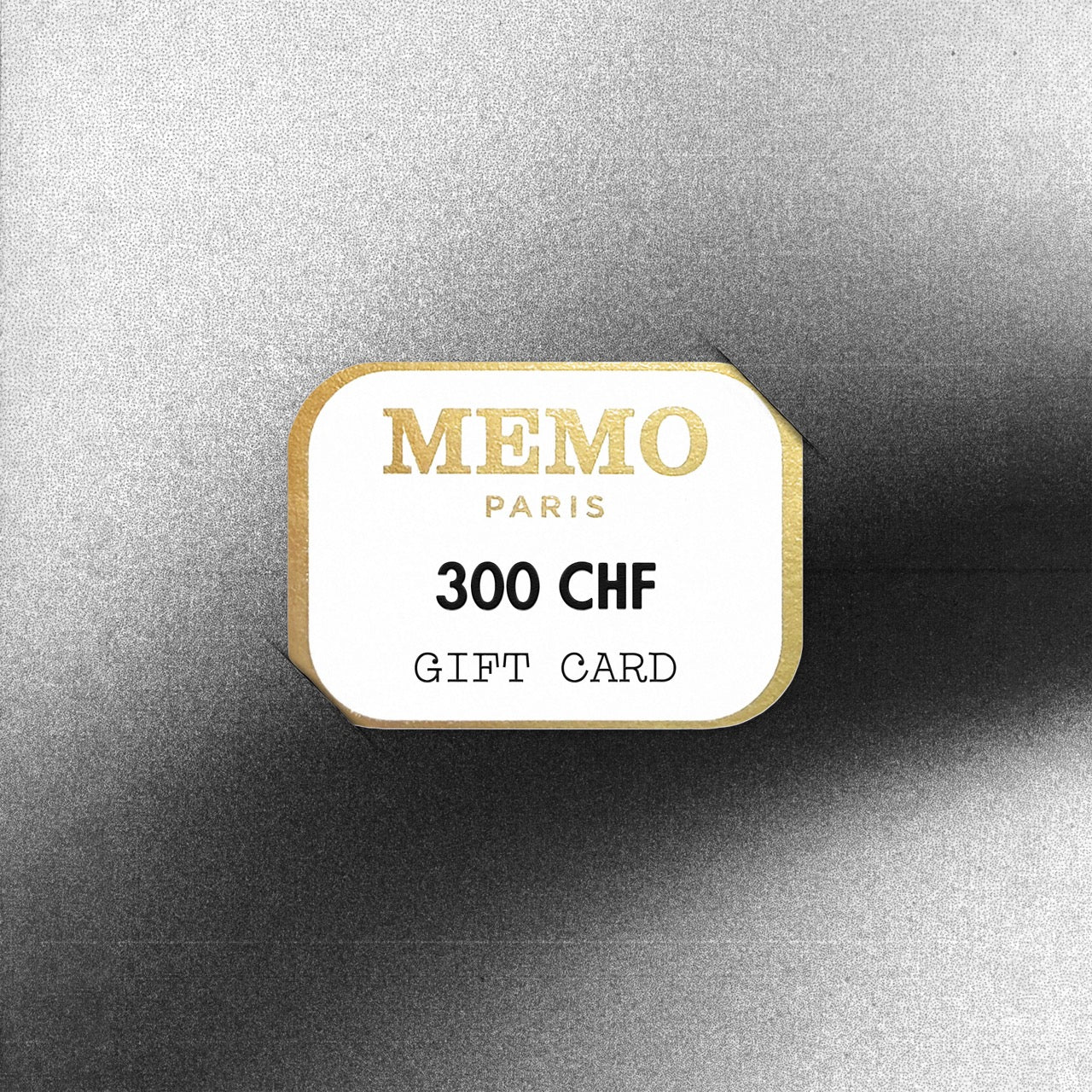 Carte cadeau Memo Paris blanche et or d'une valeur de 300 CHF, à la typographie élégante, célébrant des destinations de rêve