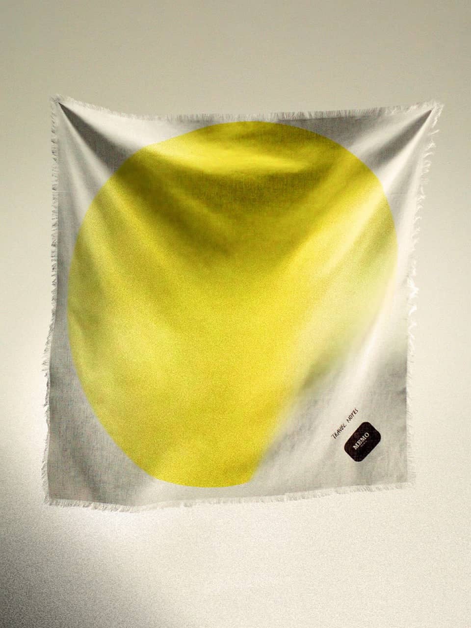 A soft, square scarf with a bold yellow circular gradient design on a white background and frayed edges.